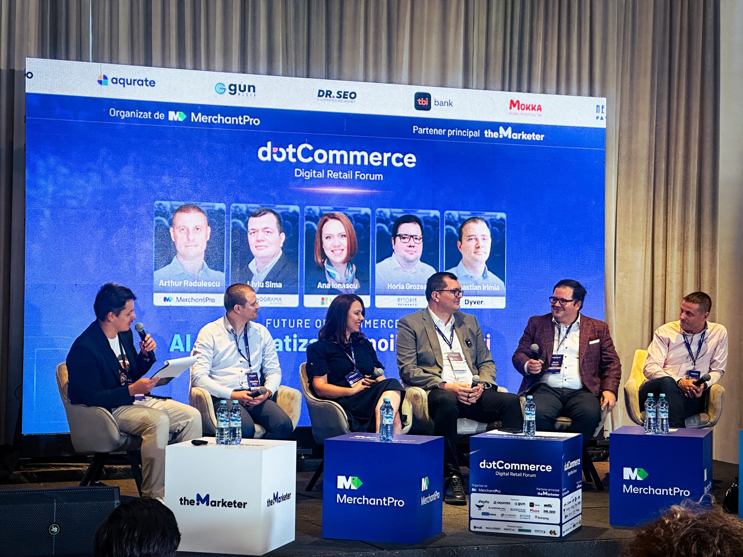 La mesa redonda sobre IA y automatización del dotCommerce Digital Retail Forum: un moderador y cinco ponentes en el escenario, ante una pantalla con la lista de participantes, entre ellos Liviu Sima, de Planograma