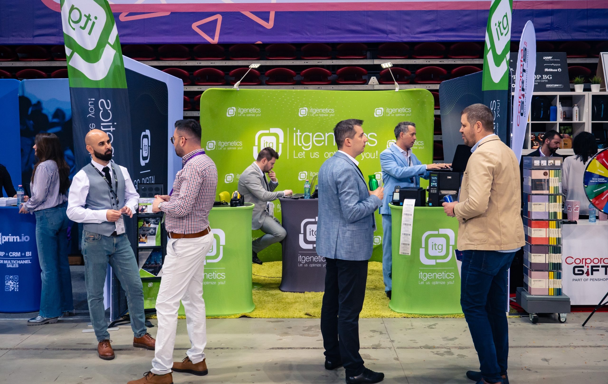 Besucher im Gespräch mit dem Team am itgenetics-Stand, auf dem Tresen geben Etikettendrucker Barcode-Etiketten aus